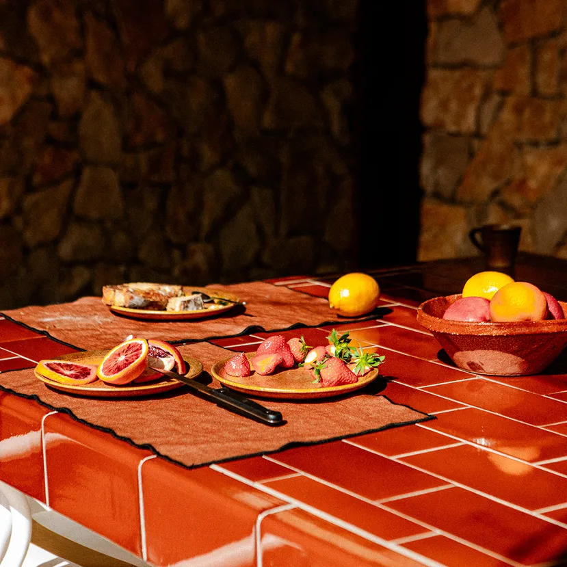 Provence dining table with linen, plates and a fruit bowl
